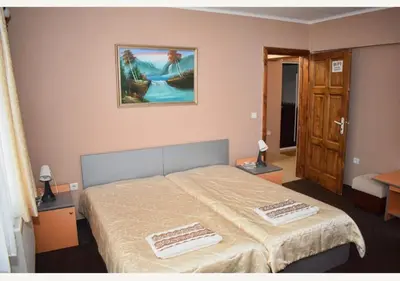 a bedroom with a bed with two towels on it at Family Hotel Miglena in Govedartsi