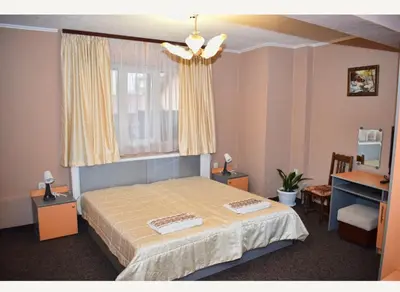 a bedroom with a bed and a window and a desk at Family Hotel Miglena in Govedartsi