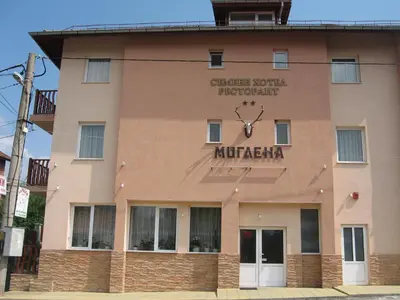 a building with a clock on the side of it at Family Hotel Miglena in Govedartsi