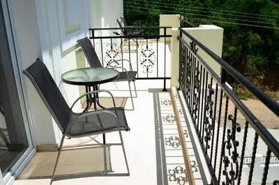 two chairs and a table on a balcony at Aleksion Palace in Ognyanovo