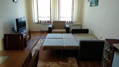 a living room with a couch and a tv at Ski Apartment D50 Cedar Lodge 4 in Bansko