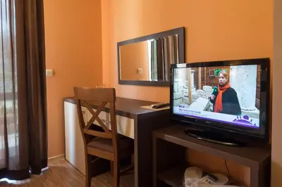 a room with a desk with a television and a chair at City Blagoevgrad Family Hotel in Blagoevgrad