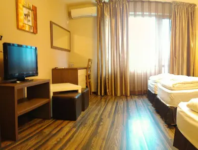 a hotel room with two beds and a flat screen tv at City Blagoevgrad Family Hotel in Blagoevgrad