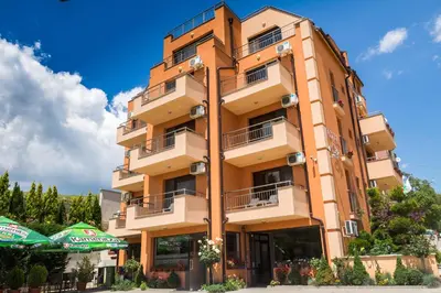 a tall building with umbrellas in front of it at City Blagoevgrad Family Hotel in Blagoevgrad