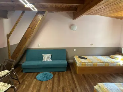 a room with two beds and a green couch at Borovets Gondola Apartment & Ski by Winter Bros in Borovets