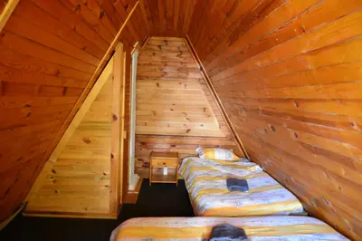 a room with two beds in a wooden cabin at Borovets Gondola Apartment & Ski by Winter Bros in Borovets