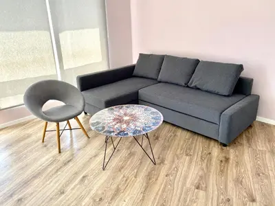 a living room with a couch and a table and a chair at Bluemarine Apartment in Sofia