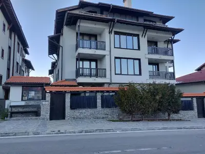 a white building with balconies on the side of a street at Mountain Escape Bansko 1BR apartment in Bansko