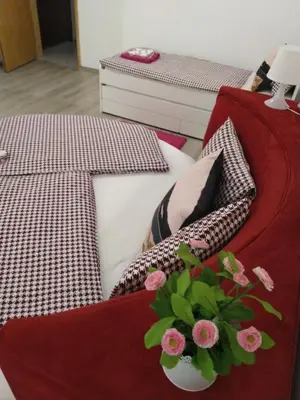 a bed with pillows and a vase with flowers on it at Sofia Peak in Sofia