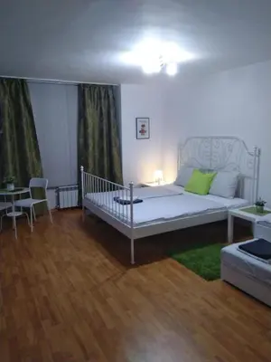 a bedroom with a white bed and a living room at Sofia Peak in Sofia