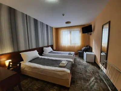 a hotel room with two beds and a television at Balkan Hotel in Chiflik