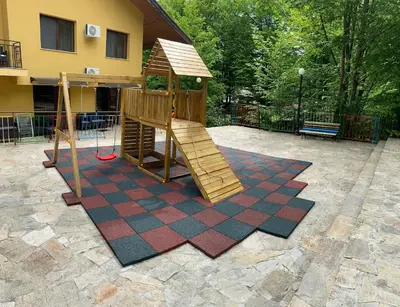 a playground with a slide in a yard at Balkan Hotel in Chiflik