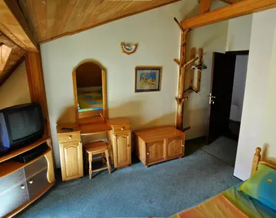 a bedroom with a tv and a vanity and a mirror at Strandzhata's House in Pasarel