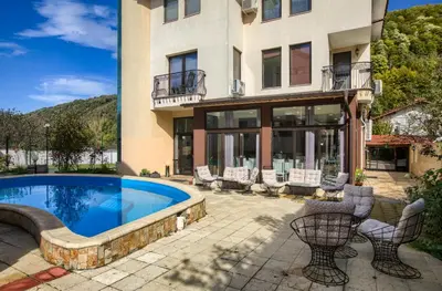 a house with a swimming pool and chairs at Family Hotel Zornitsa in Ribarica