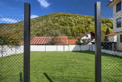 a fence with a hill in the background at Family Hotel Zornitsa in Ribarica