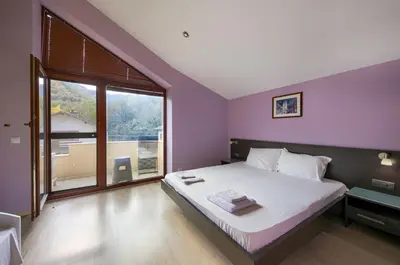 a bedroom with a large bed and a large window at Family Hotel Zornitsa in Ribarica