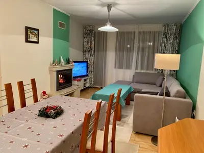 a living room with a table and a living room with a couch at Aparthotel - Monastery 3, 1 Bedroom Apartment in Pamporovo