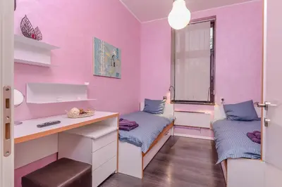 a pink room with two beds and a desk at Champs-Élysées Sofia 2-BDR, 2-BTHR Tsar Simeon Suite by Flat Mаnager in Sofia