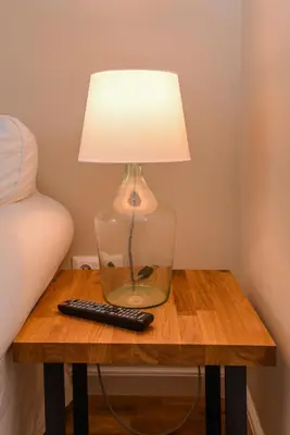 a lamp sitting on a table with a remote control at cО́coEllie - Aesthetic 2BD Apt Near National Palace by Flat Mаnager in Sofia