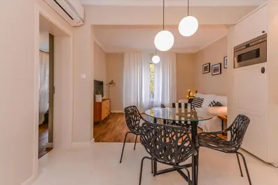 a dining room with a glass table and chairs at cО́coEllie - Aesthetic 2BD Apt Near National Palace by Flat Mаnager in Sofia
