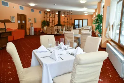 a dining room with white tables and white chairs at Hotel Borovets Edelweiss in Borovets