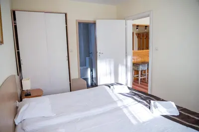 a bedroom with a white bed and a mirror at Hotel Borovets Edelweiss in Borovets
