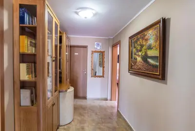 a hallway with a book shelf and a painting on the wall at Guest House Roden Dom in Koprivshtitsa