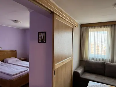 a bedroom with a bed and a window and a chair at Guest House Roden Dom in Koprivshtitsa