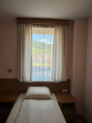 a bedroom with two beds in front of a window at Guest House Roden Dom in Koprivshtitsa
