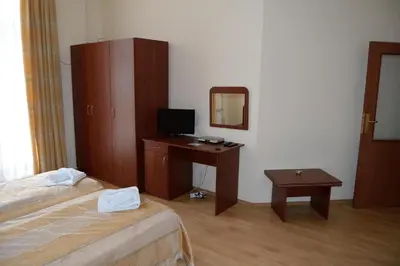 a hotel room with a bed and a desk with a television at Borovets Holiday Apartments - Different Locations in Borovets in Borovets