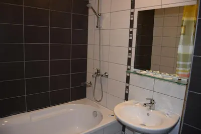 a bathroom with a sink and a tub and a mirror at Borovets Holiday Apartments - Different Locations in Borovets in Borovets