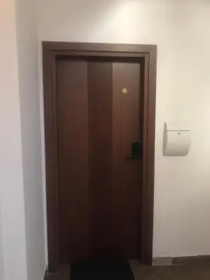 a wooden door in a room with a tissue dispenser at Lilia 2 Self-Check in apartment in Sofia