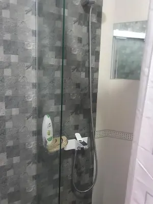 a bathroom with a shower with a banana on a sink at Lilia 2 Self-Check in apartment in Sofia