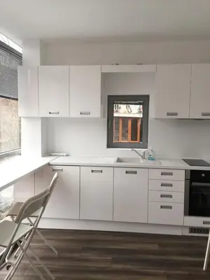 a kitchen with white cabinets and a sink and a window at Lilia 2 Self-Check in apartment in Sofia