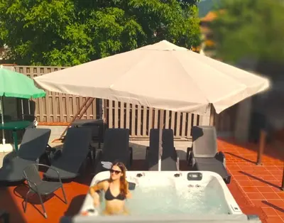 a woman sitting in a bath tub with an umbrella at 7 Pools SPA Boutique Hotel in Bansko