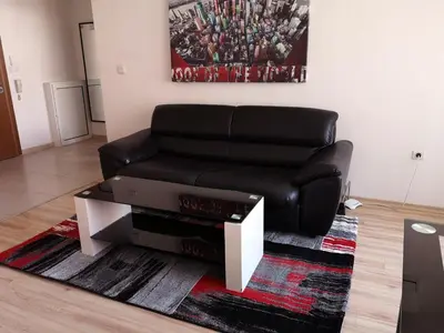 a black leather couch sitting in a living room at Venice Apartments in Sofia