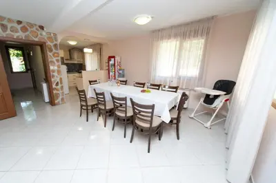 a dining room with a white table and chairs at Villa Drecheva in Ognyanovo