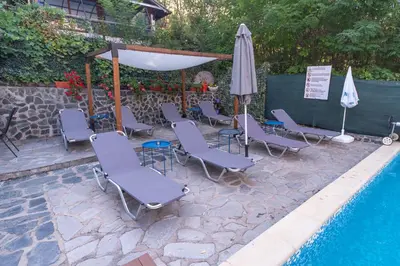 a group of chairs and an umbrella next to a pool at Villa Drecheva in Ognyanovo