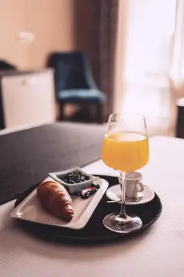 a glass of orange juice and a pastry on a tray at Plaza Hotel Plovdiv - Free Parking in Plovdiv