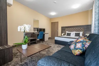 a hotel room with a bed and a couch at Plaza Hotel Plovdiv - Free Parking in Plovdiv