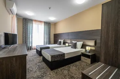 a hotel room with two beds and a flat screen tv at Plaza Hotel Plovdiv - Free Parking in Plovdiv