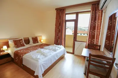 a bedroom with a bed and a large window at Къща за гости 