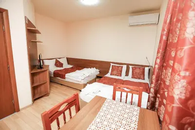 a small room with two beds and a table at Къща за гости 