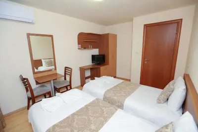 a hotel room with two beds and a desk and a mirror at Къща за гости 