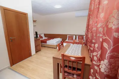 a room with a table and chairs and a bedroom at Къща за гости 