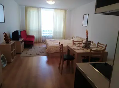 a living room with a table and a room with a bed at Aspen golf studio apartment D208 in Razlog
