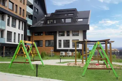 a playground with two swings in front of a building at Aspen golf studio apartment D208 in Razlog