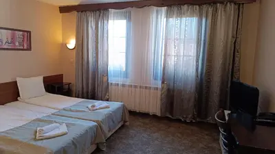 a hotel room with two beds and a window at Hotel St. George Pobedonosets in Bansko
