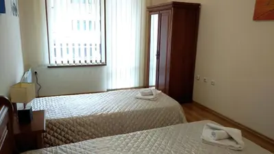 two beds in a room with a window and two towels at Pine Tree Apartment 2 - B7 in Bansko