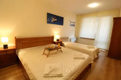 a hotel room with two beds and a table at Pine Tree Apartment 2 - B7 in Bansko